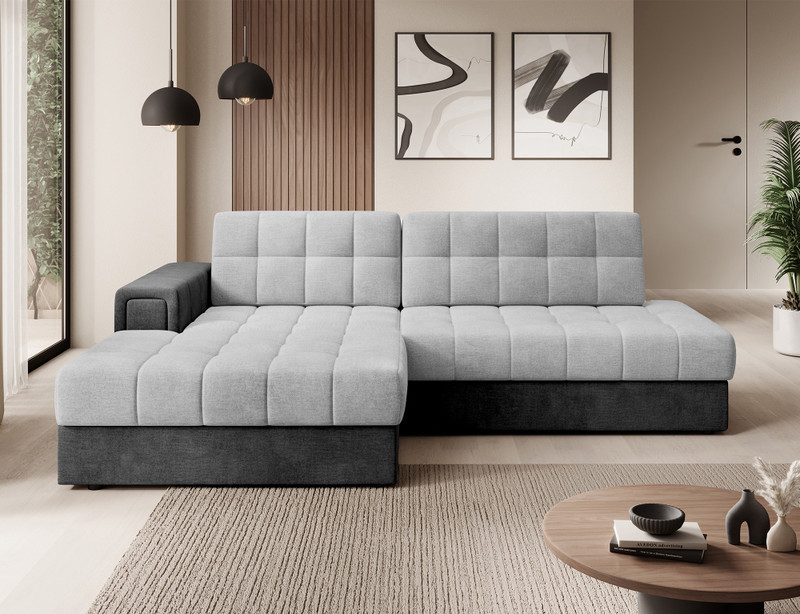 Yolanda corner sofa bed with light grey tufted seats and back on a charcoal base, chaise on the left, beside a round wooden coffee table and a woven rug