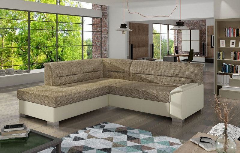 Mistral corner sofa bed with sand-coloured woven seats and back on a cream base and arm, corner section on the left, in an open-plan room with tall windows and a geometric rug
