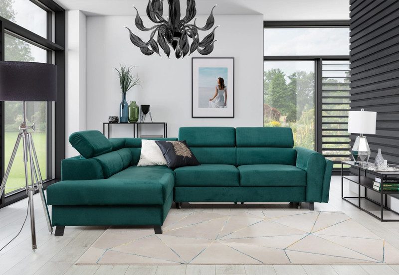 Deep green Thorncliff corner sofa bed with the chaise on the left and one headrest raised, in a bright living room with tall windows and a geometric cream rug