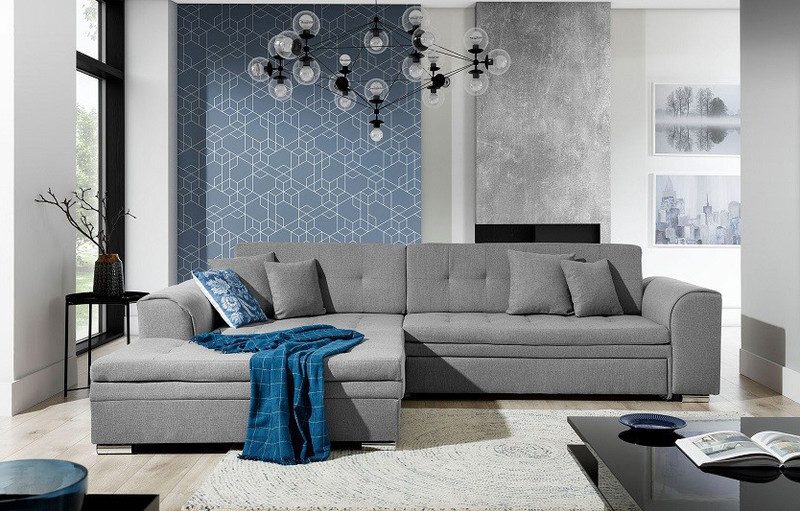 Grey Rosslyn corner sofa bed with the chaise on the left, a navy check throw and a blue patterned cushion, in front of blue geometric wallpaper