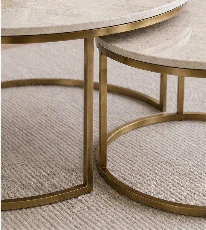 Pair of round Fernleigh nesting coffee tables with cream terrazzo-look tops and brushed-brass ring bases on a textured rug
